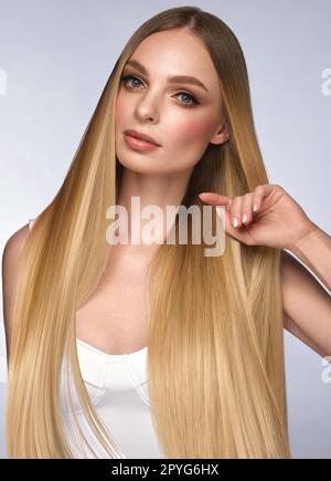 Beautiful blond girl with a perfectly smooth hair, and classic make-up. Beauty face and hair. Stock Photo