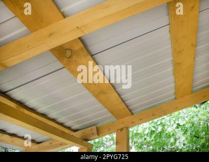 Close-up of wooden roof rafters with metal corrugated board, bottom ...