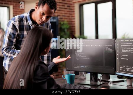 System engineers using binary code to script security system, working in it development agency. Asian software developer typing on keyboard to create artificial intelligence script. Stock Photo
