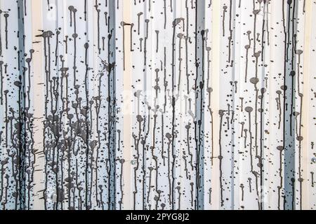 Background - interesting pattern made by grainy paint splattered  and running on light metal siding with striped effect Stock Photo