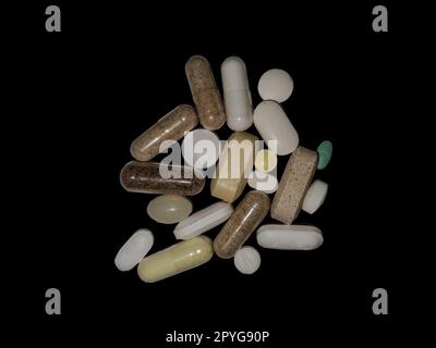 Many assorted pills jumbled together on a white surface - a combination of supplements and prescription drugs Stock Photo