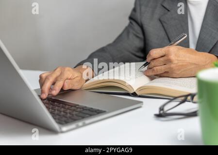 Woman hands with pen writing on notebook in the office.learning, education and work.writes goals, plans, make to do and wish list on desk. Stock Photo