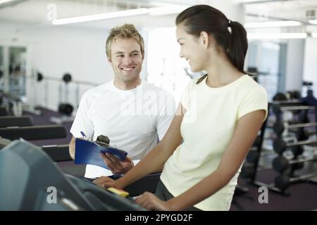 Youre doing great. an attractive young woman working out with her personal trainer. Stock Photo