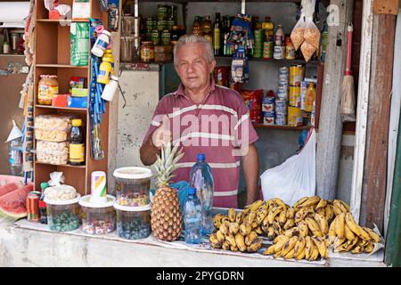 This is his livelihood. Portrait of a street vendor selling a variety of food at his stall. Stock Photo