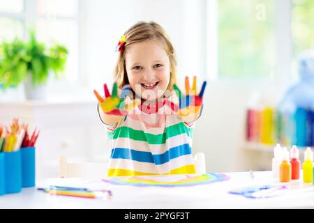 Kids Paint. Child Painting In White Sunny Study Room. Little Girl Drawing  Rainbow. School Kid Doing Art Homework. Arts And Crafts For Kids. Paint On  Children Hands. Creative Little Artist At Work.