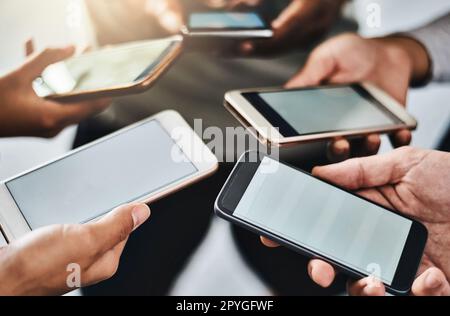 Getting fit in the age of the app. a group of unrecognizable people using their mobile phones together in the gym. Stock Photo
