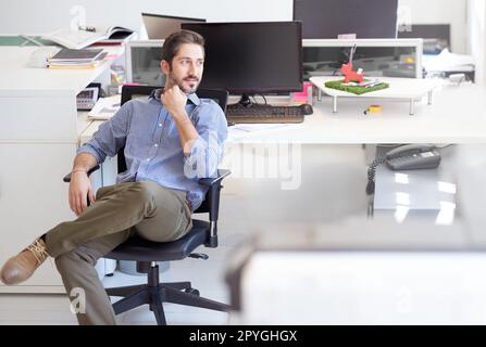 Full of creative ideas. a young designer sitting at his workstation in an office. Stock Photo