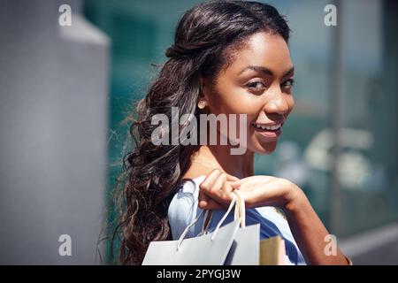 Do more of what makes you happy. Portrait of a beautiful woman holding her shopping bags. Stock Photo