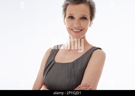 She decided to pursue her dreams. A confident mature businesswoman standing against a white background. Stock Photo