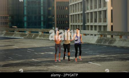 Nothing but us and the road. joggers running down an empty highway in the morning. Stock Photo