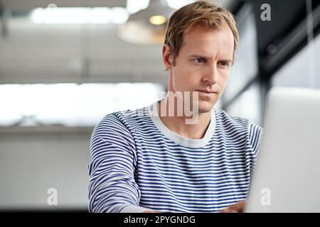 Hard work gets him results. a man working on a laptop in an office. Stock Photo