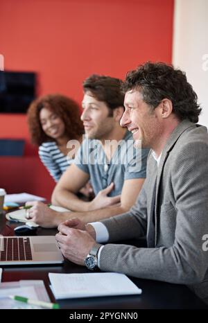 Getting down to business. a group of colleagues having a meeting in a boardroom. Stock Photo