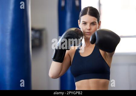 Fitness, kickboxing and portrait of woman athlete doing a cardio workout while training for a match. Sports, exercise and female boxer getting ready for a fight in sport, wellness and health gym. Stock Photo
