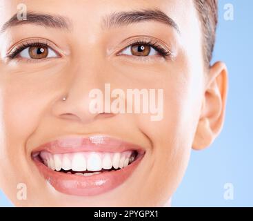 Teeth, dental and face portrait of woman with clean smile, teeth whitening and oral self care on blue background. Tooth implant, healthcare and beauty model with makeup, cosmetics and facial skincare Stock Photo
