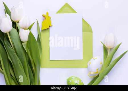 Template for Easter greeting card. Blank card with an envelope and bouquet of white tulips Stock Photo