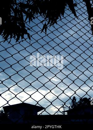 Metal wire mesh and evening blue sky in background Stock Photo