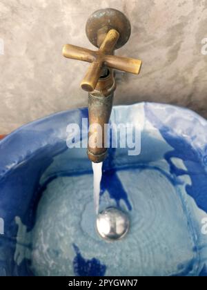 Water runs from a metal water tap. Close up Stock Photo