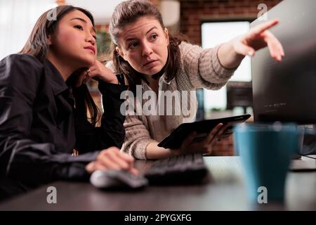 Tech enginners collaborating on coding project, discussing about programming algorithm for new cloud computing working in it company. Diverse team of software developers running database system code. Stock Photo