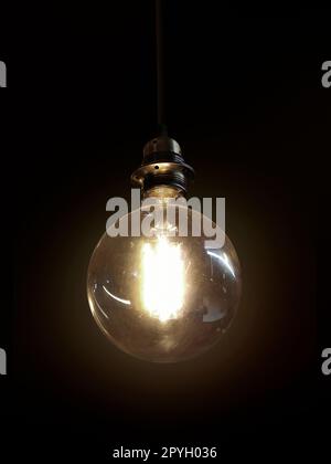 Glowing light bulb on dark background Stock Photo