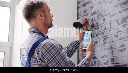 Technician Adjusting CCTV Stock Photo