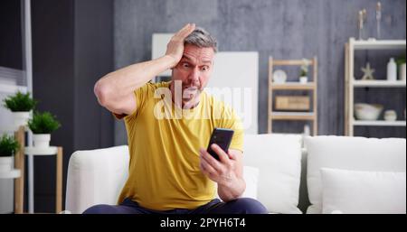Scam Text Message. Frustrated Confused Man Stock Photo