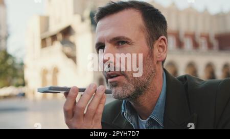 Man sends voice message on old town background Stock Photo
