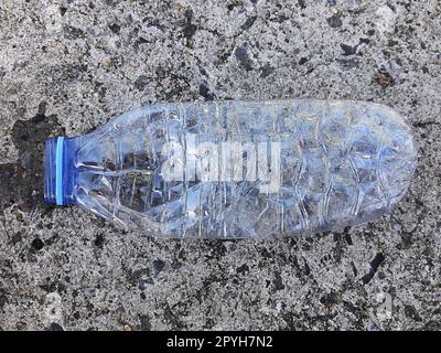 A plastic bottle of drinking water littering on the street ground Stock Photo