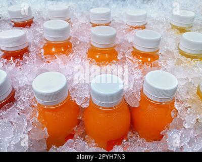 Bottles of fresh fruit juices in the ice bucket, which are orange juice, passion fruit juice, pineapple juice Stock Photo