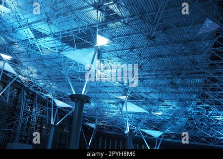 Metal structures under the ceiling. Decorative details of the airport ceiling . Concrete beams, glass windows and metal elements as public building interior design. Abstract avant-garde architecture. Stock Photo