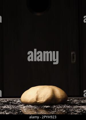 Floured organic yeast dough lies on the kitchen work surface Stock Photo