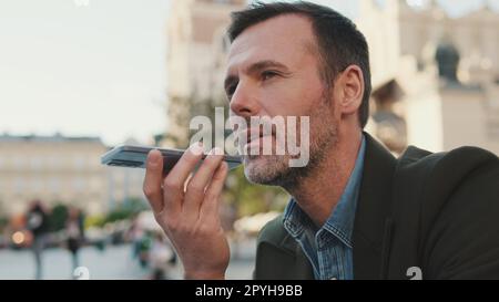 Man sends voice message on old town background Stock Photo