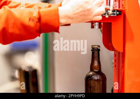 mechanical capping of beer bottles in the brewery Stock Photo