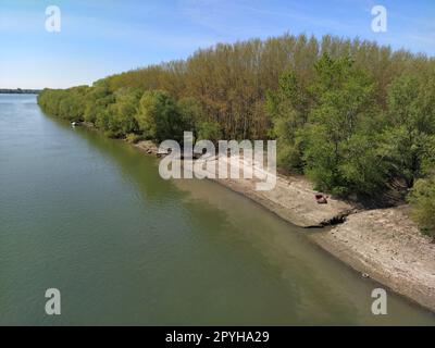 A large city drain drains sewage into a canal that flows into the river. Ecological problem. The concept of environmental protection and ecology. Colorful water in the pond. Nature pollution Stock Photo