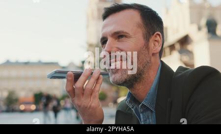 Man sends voice message on old town background Stock Photo