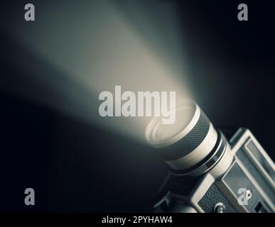 Vintage film camera super 8mm with spotlight over black background. Stock Photo