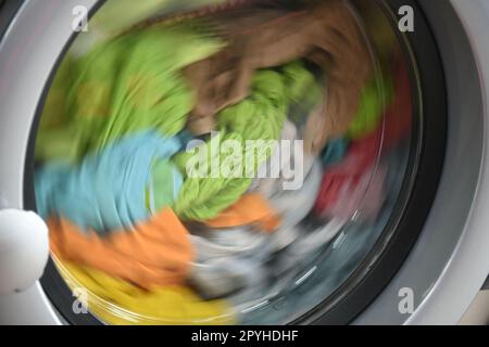 a stainless steel washing machine drum filled with colorful laundry, Alicante Province, Costa Blanca, Spain Stock Photo