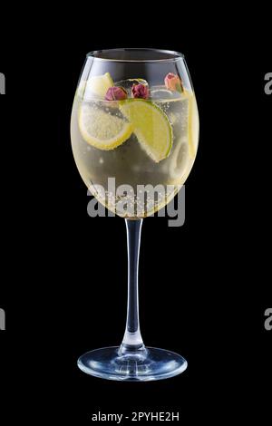 Cold white sangria with dry rosebuds in wine glass isolated on black Stock Photo