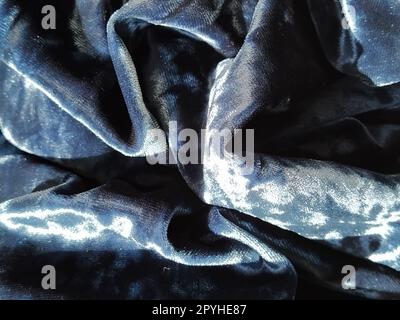 Velvet velor cloth background with glowing light and dark shadows. Background for theater and fashion design themes. Nice blue fabric with overflow Stock Photo