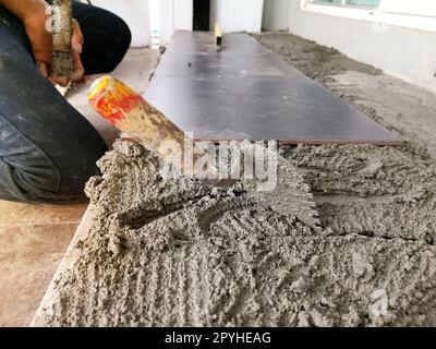 Close-up Installing tiles floor in construction work Stock Photo
