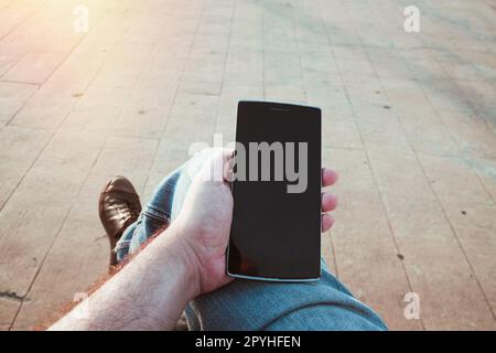 Man using the smartphone outdoors Stock Photo