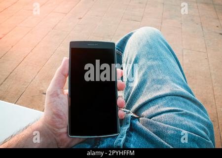 Man using the smartphone outdoors Stock Photo