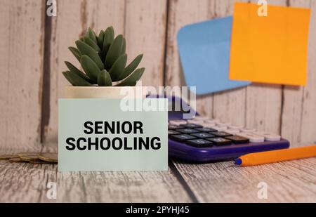 White card with the text Senior Schooling on study desk Stock Photo