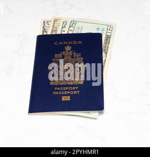 Canadian Passport and American dollars on a white marble background Stock Photo