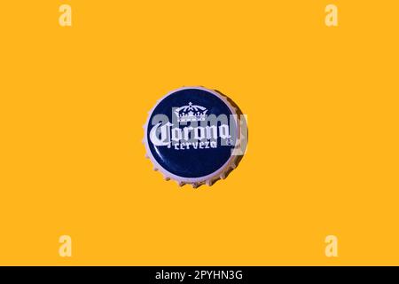 Corona beer bottle cap, on a yellow background. Concept for beer, drinks, alcohol, soft drinks, soft drinks, metal, industry and collectibles. Stock Photo