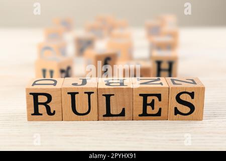 Word Rules made of cubes with letters on light wooden table Stock Photo