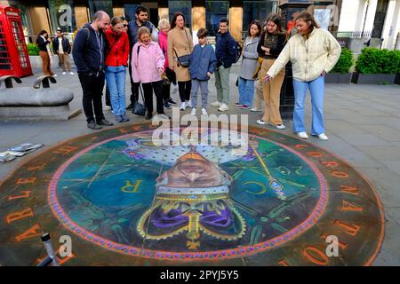 Members of the public admire the chalk portrait by Julian Beever on a pavement close to Trafalgar Square ahead of the King's coronation. Stock Photo