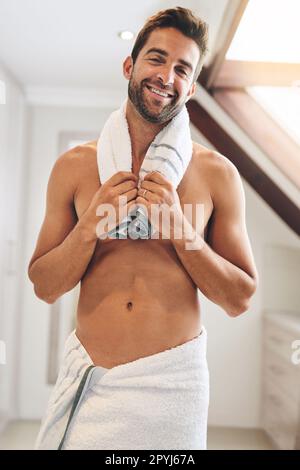 That shower was great. Cropped portrait of a handsome young man holding a towel around his neck in his bathroom at home. Stock Photo