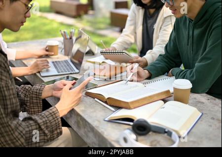 Cropped image, Group of Asian college students preparing for the exam, doing homework or school project together at a campus park. Education concept Stock Photo