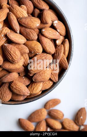 Fresh almonds in a bowl on white background. Bowl of almonds on white background. Close-up. Stock Photo