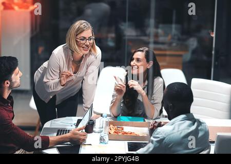 Teaming up to make it a productive night. colleagues having a meeting during a late night in a modern office. Stock Photo